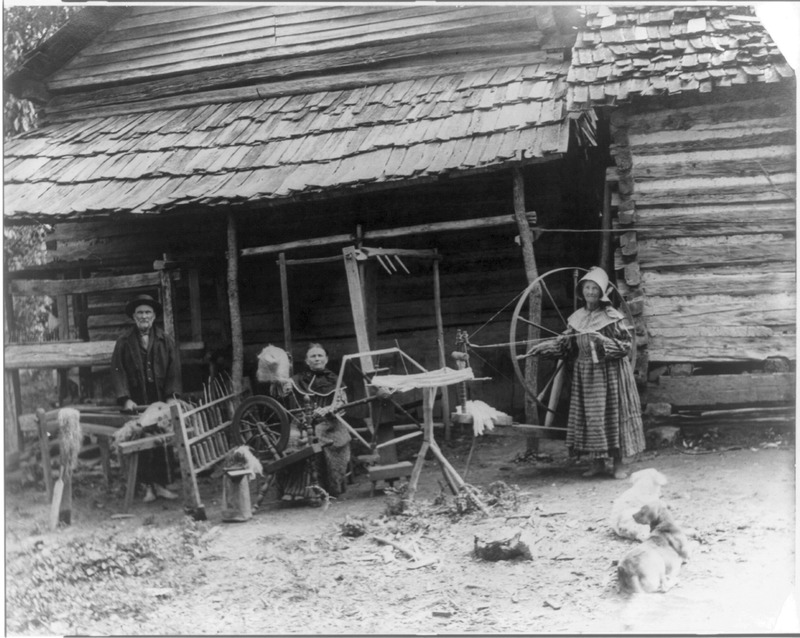 The Faust family, Anderson County, Tenn. at spinning wheel in front of cabin<br />
